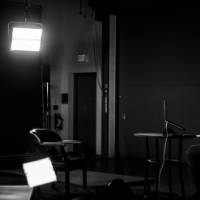man sitting in studio, with studio lights on, giving a virtual presentation while seated